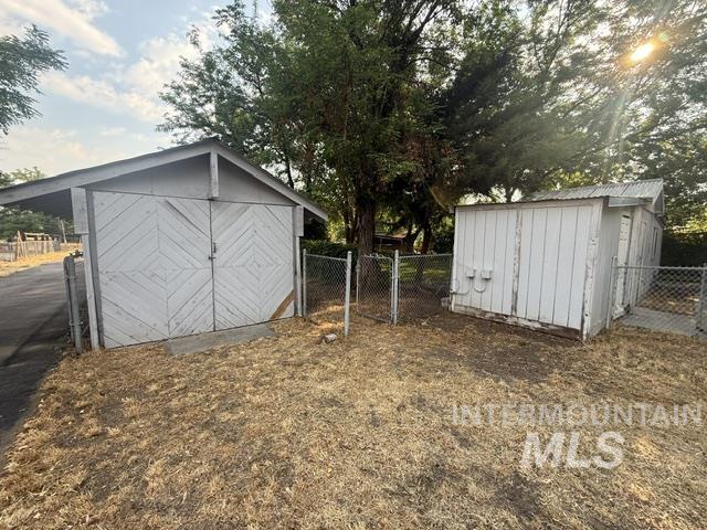 1360 Pioneer Road Weiser, ID 83672 - Photo 38 of 47 Two detached outbuildings with chain link fencing and established trees