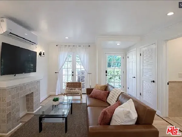 a living room with furniture a flat screen tv and a fireplace