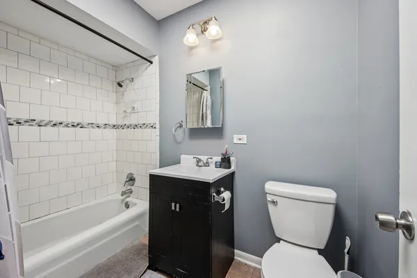 a bathroom with a toilet sink vanity tub and shower