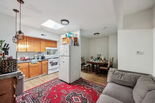 a living room with furniture and a dining table with appliances