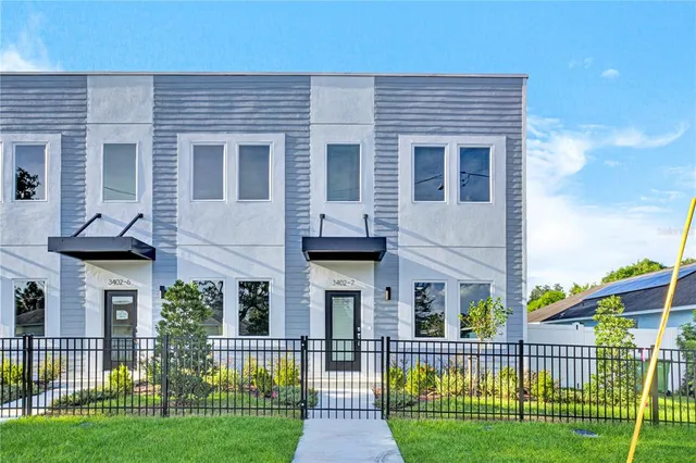a front view of a house with a garden and plants