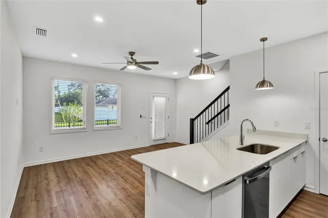 a kitchen with a sink a faucet a chandelier and living room view