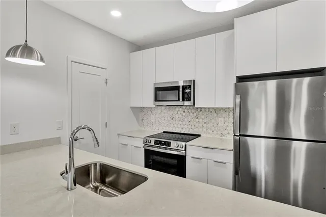 a kitchen with a refrigerator sink and microwave