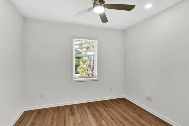 an empty room with a window and a fan