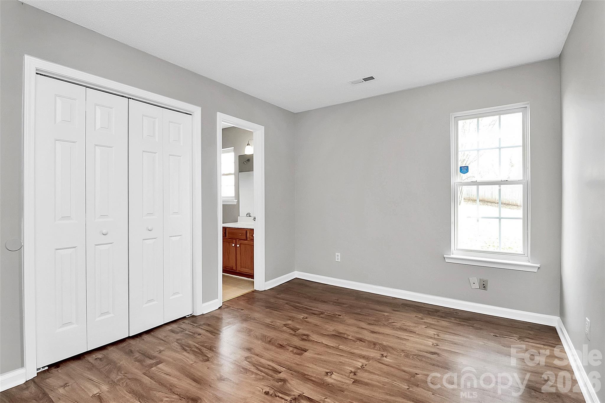 1044 Sandy Point Drive Southwest Concord, NC 28025 - Photo 21 of 32 a view of an empty room with wooden floor and a window