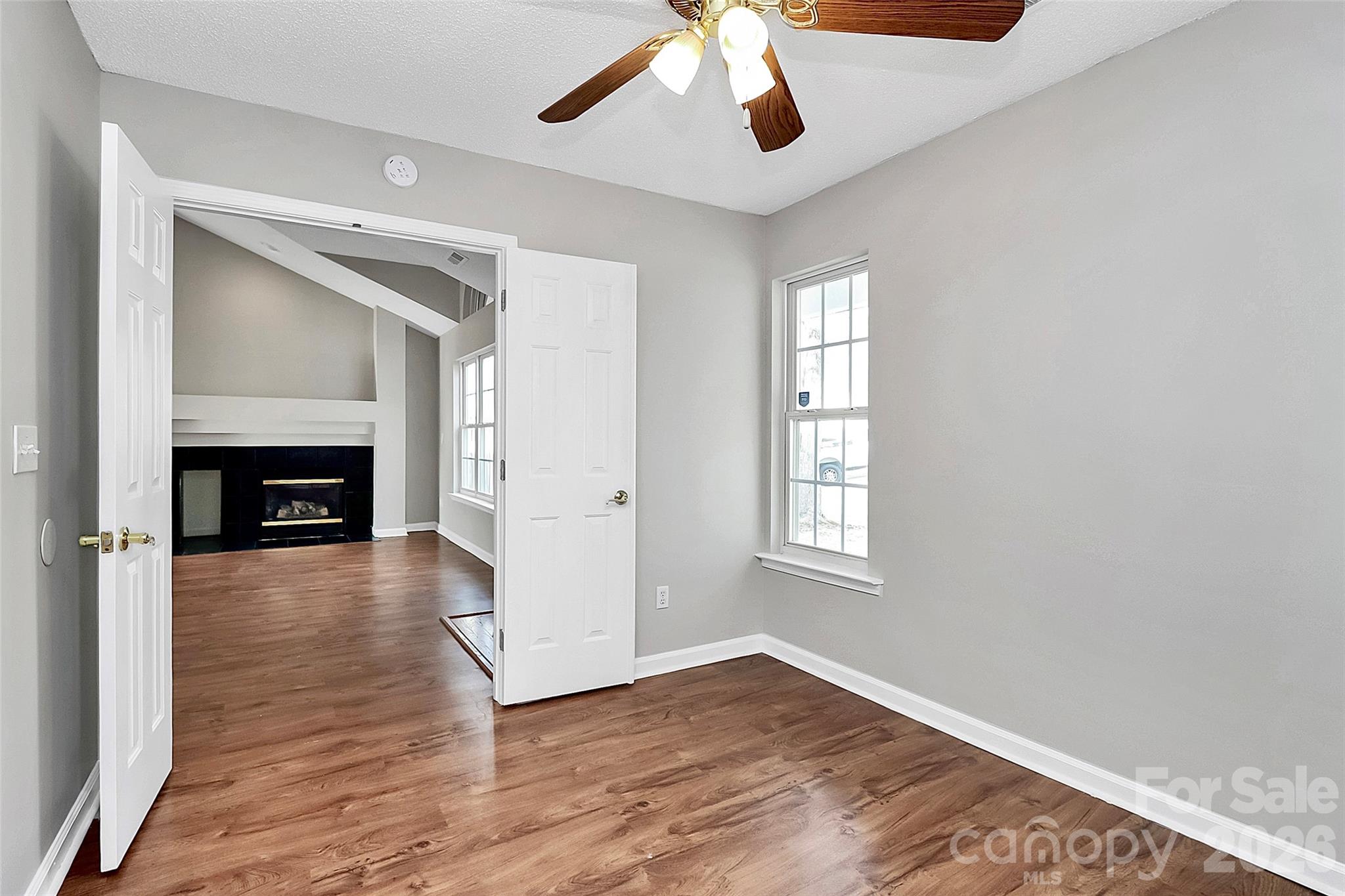 1044 Sandy Point Drive Southwest Concord, NC 28025 - Photo 24 of 32 an empty room with wooden floor fireplace and windows