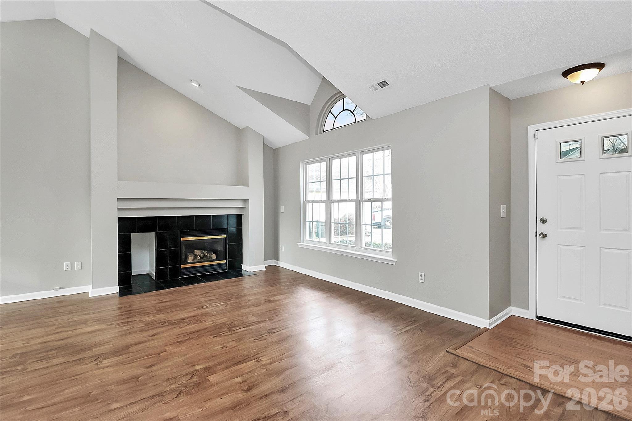 1044 Sandy Point Drive Southwest Concord, NC 28025 - Photo 4 of 32 a view of an empty room with wooden floor fireplace and a window