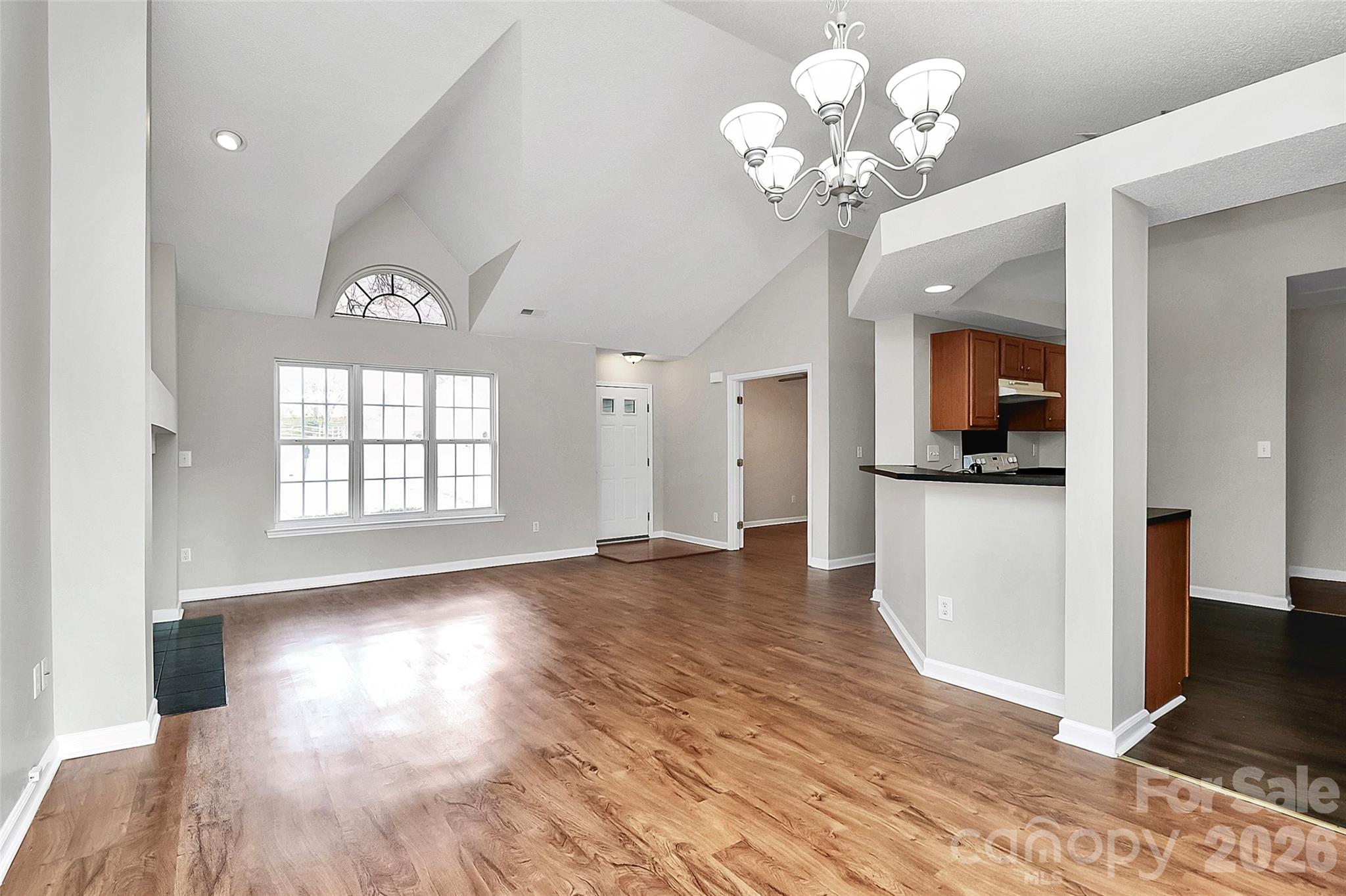 1044 Sandy Point Drive Southwest Concord, NC 28025 - Photo 7 of 32 a view of a big room with wooden floor a chandelier and windows