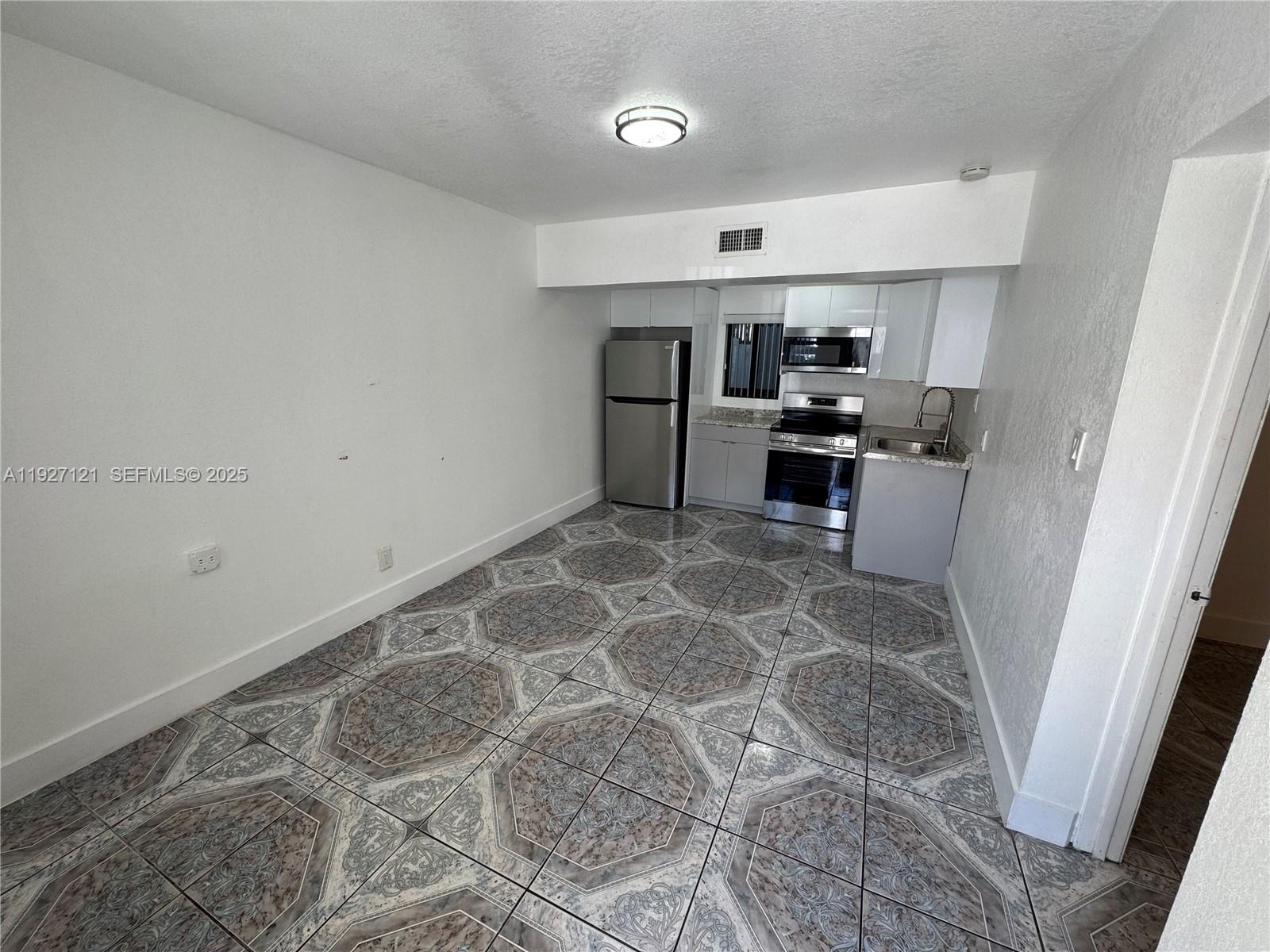 a kitchen with granite countertop a sink cabinets and stainless steel appliances
