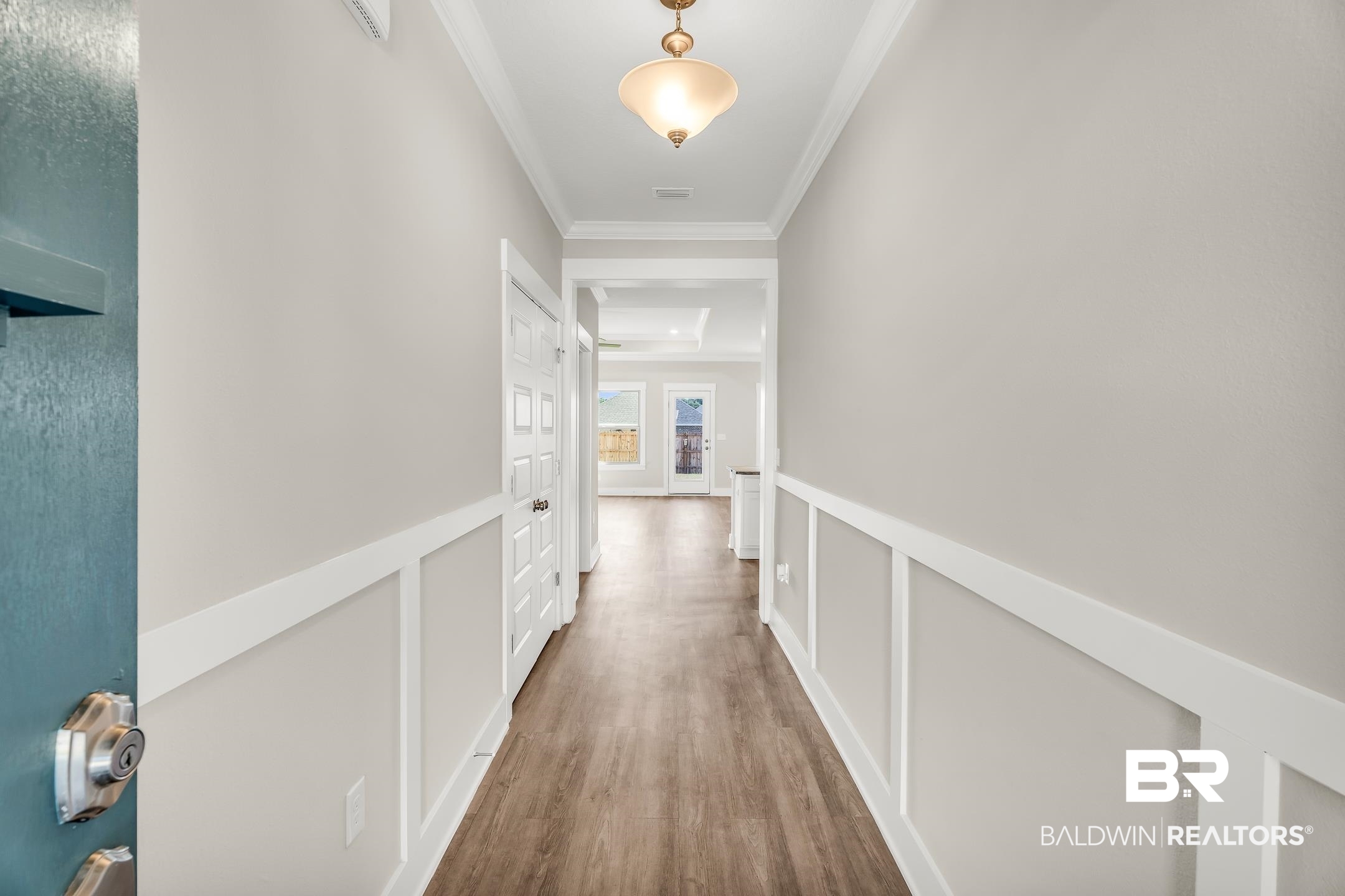 1720 Partridge Street Foley, AL 36535 - Photo 6 of 32 Corridor with a tray ceiling, crown molding, and hardwood / wood-style flooring