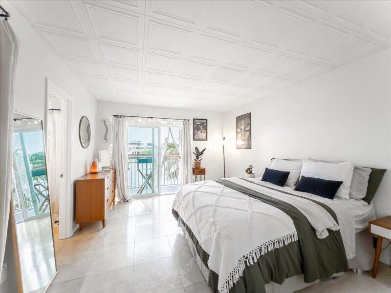 201 Coppitt Road, Unit 202A Key West, FL 33040 - Photo 8 of 21 a bedroom with a bed and glass walk in closet