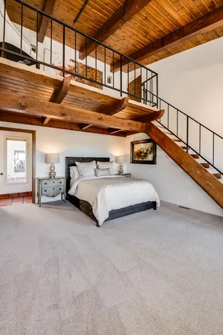 a bedroom with a bed chair and a large window