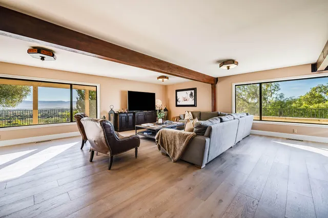 a view of a patio with couches table and chairs with wooden floor