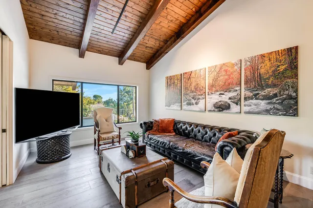 an aerial view of a house with swimming pool and large trees