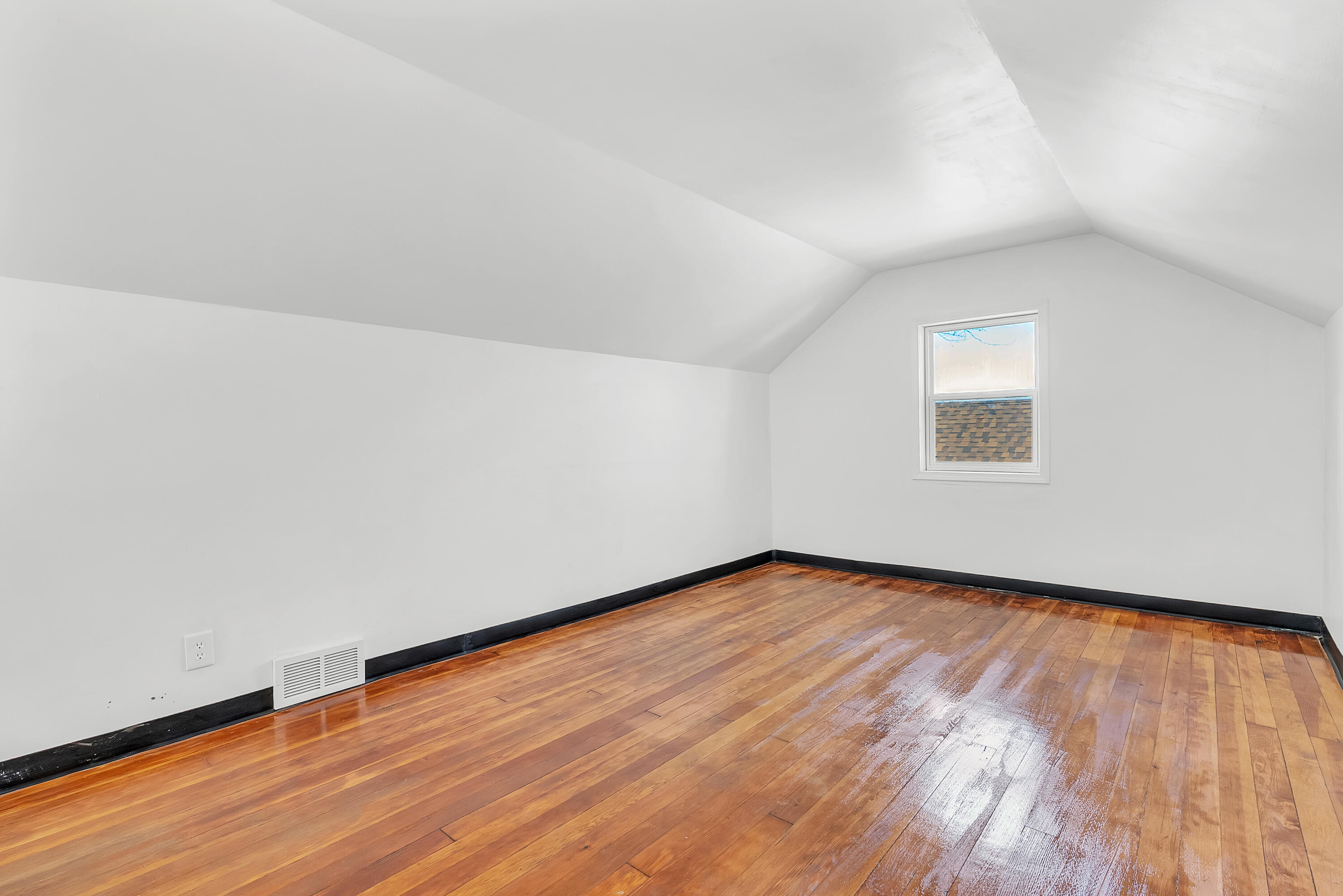 263 Rutledge Street Gary, IN 46404 - Photo 17 of 21 a view of an empty room with wooden floor and a window