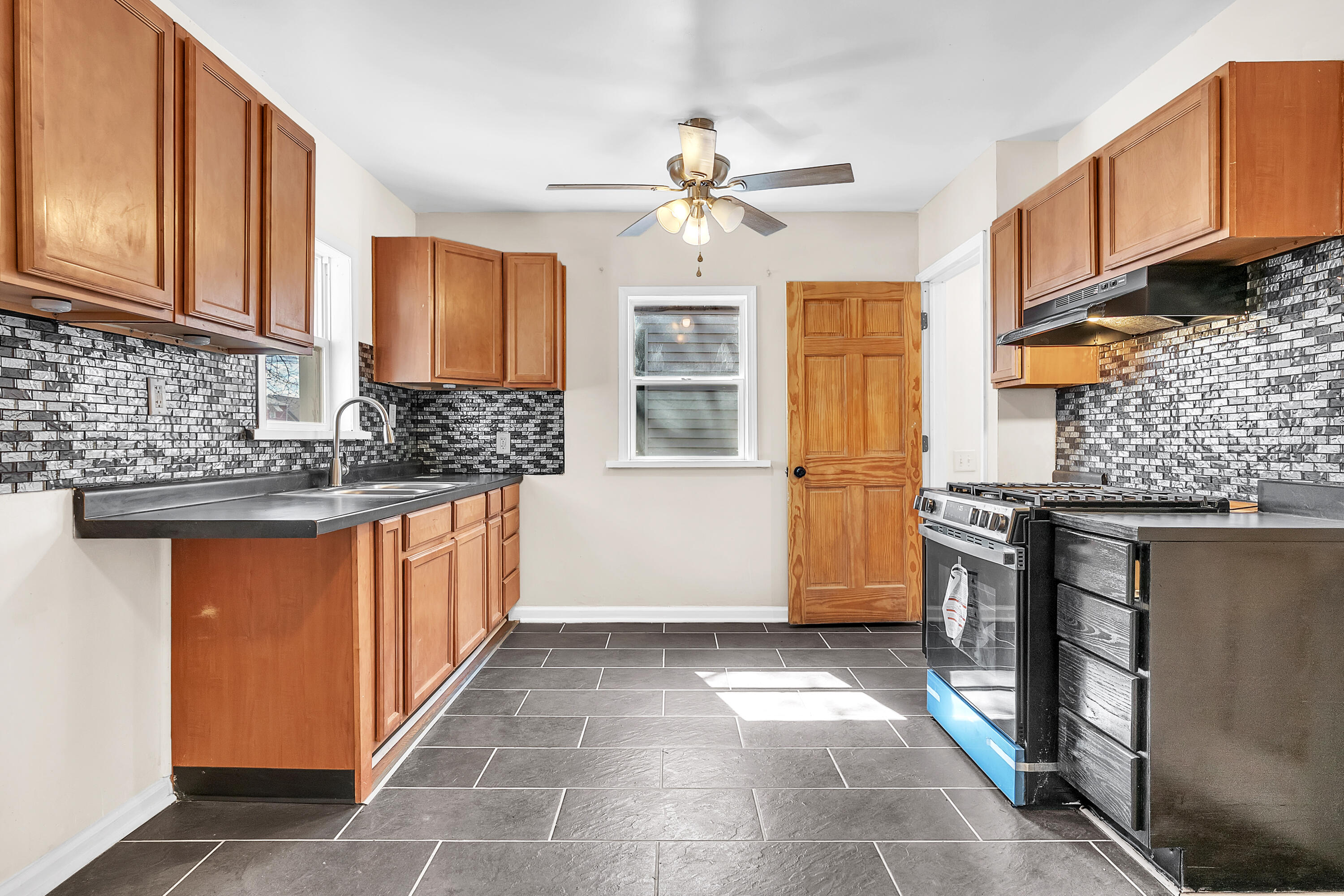 263 Rutledge Street Gary, IN 46404 - Photo 10 of 21 a kitchen with stainless steel appliances granite countertop a stove a sink and a microwave