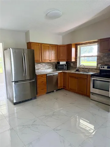a view of a hallway to a livingroom with furniture and a window