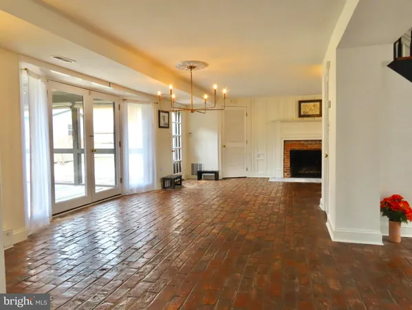 a view of an empty room with a fireplace and a window