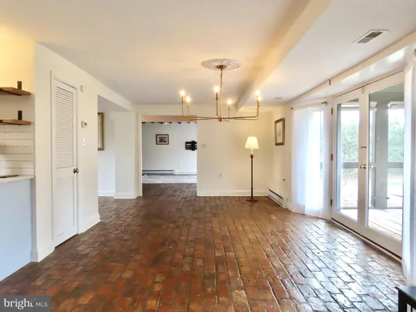 a view of a big room with wooden floor and windows