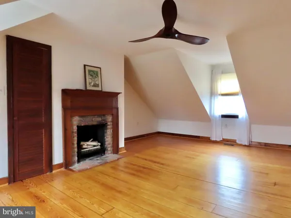a view of an empty room with exposed radiator and fireplace