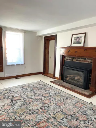 an empty room with windows and fireplace