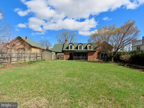 a view of a big house with a big yard and large trees