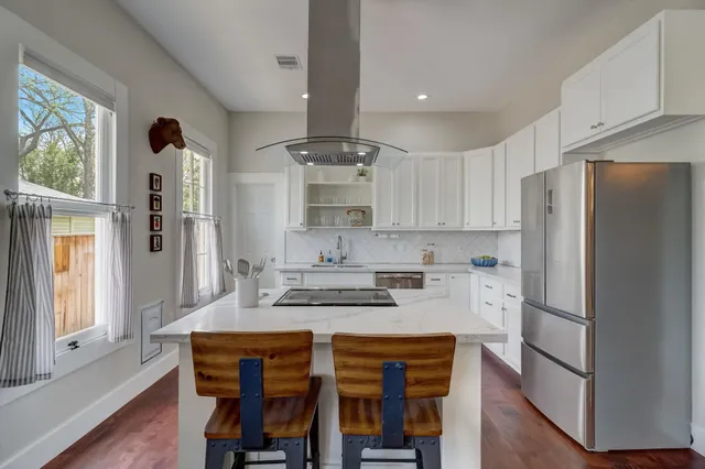 a kitchen with stainless steel appliances granite countertop a refrigerator and a stove top oven