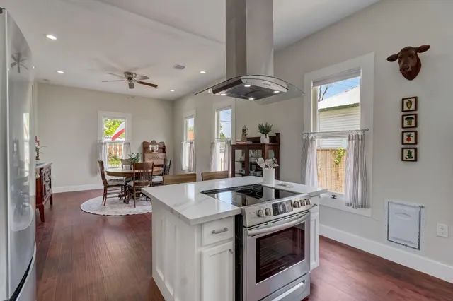 a kitchen that has a stove a table and chairs in it