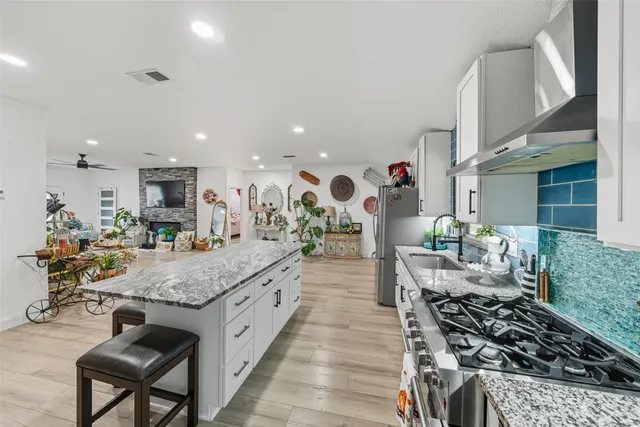 a kitchen with stainless steel appliances granite countertop a stove top oven a sink and a counter space