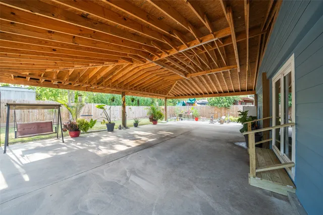 a view of a backyard with wooden floor and iron fence