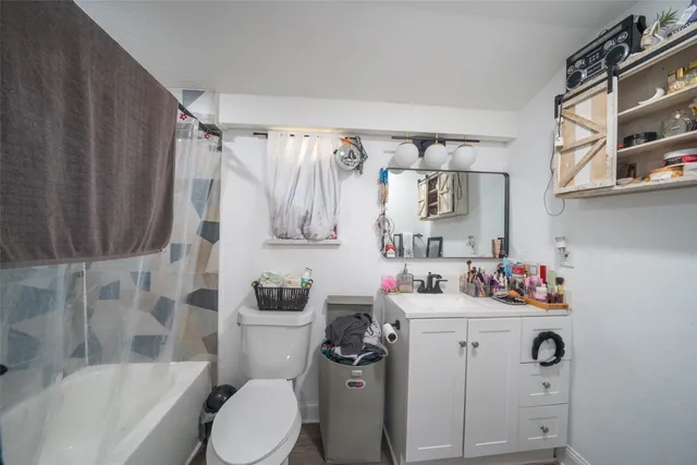 a bathroom with a sink toilet vanity tub and shower