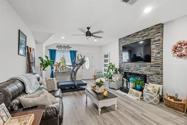 a living room with furniture a fireplace and a flat screen tv