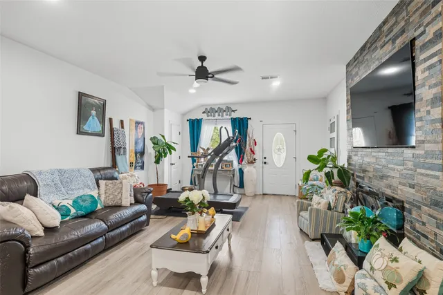 a living room with furniture a wooden floor and a chandelier