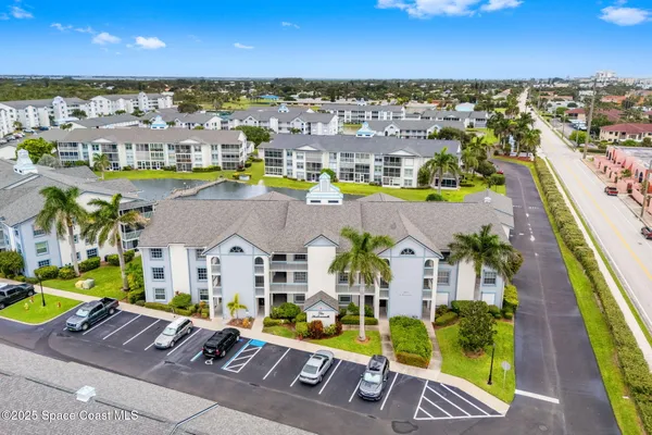 an aerial view of residential houses with outdoor space and ocean view