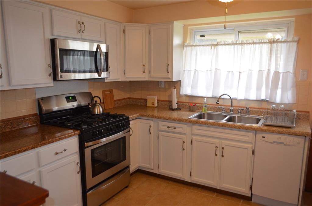 132 Starling Drive McKees Rocks, PA 15136 - Photo 11 of 25 Spacious kitchen updated with white cabinets, new hardware, counter tops. Ceramic tile wainscot and back splash, Lighted ceiling fan, newer stainless gas stove and microwave. Built in dishwasher, refrigerator stays