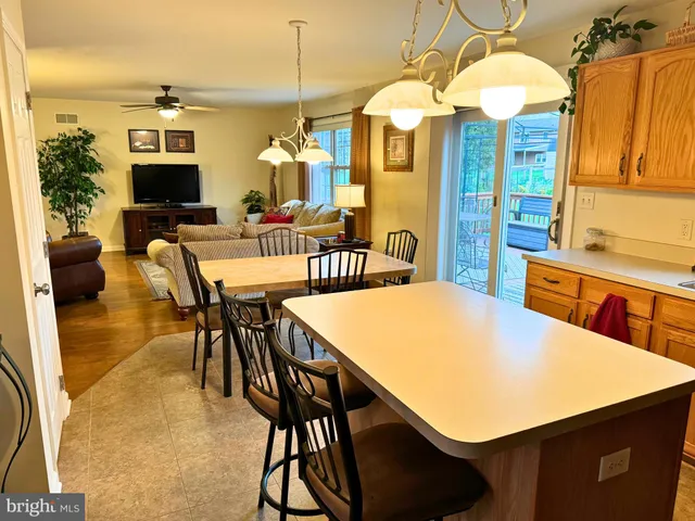 a kitchen with stainless steel appliances a table chairs and a refrigerator