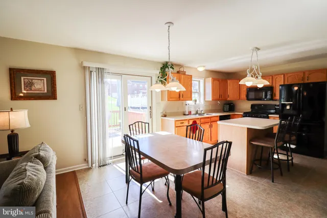 a dining room with wooden floor a chandelier a wooden table and chairs