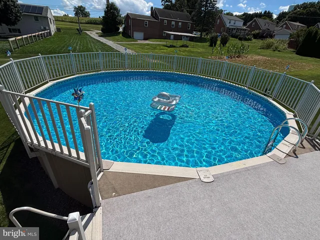 a view of a fountain in front of a house with a big yard