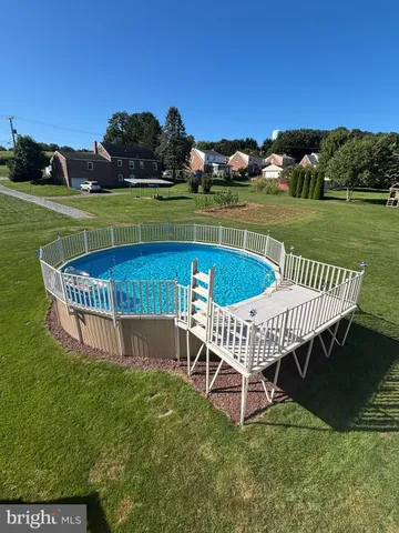 a view of a backyard with couches plants and large trees
