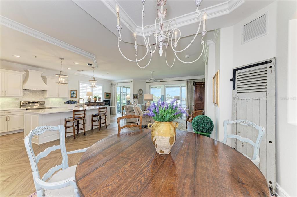 1151 Riverscape Street, Unit 1151 Bradenton, FL 34208 - Photo 12 of 62 a view of a dining room with furniture a chandelier and wooden floor