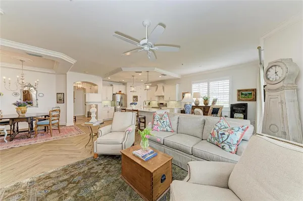 a kitchen with stainless steel appliances a dining table chairs refrigerator and cabinets