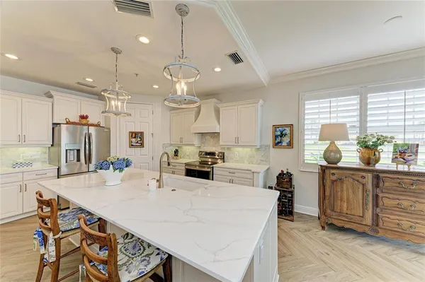 a large kitchen with kitchen island a large counter top space a sink stainless steel appliances and cabinets