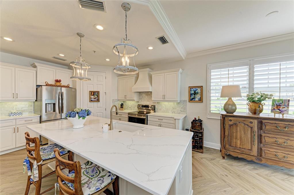 1151 Riverscape Street, Unit 1151 Bradenton, FL 34208 - Photo 20 of 62 a kitchen with stainless steel appliances a table chairs refrigerator and sink