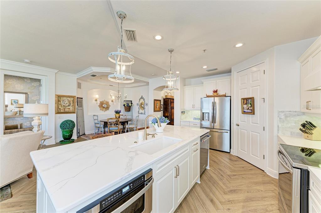 1151 Riverscape Street, Unit 1151 Bradenton, FL 34208 - Photo 22 of 62 a large kitchen with kitchen island a large counter top space a sink stainless steel appliances and cabinets