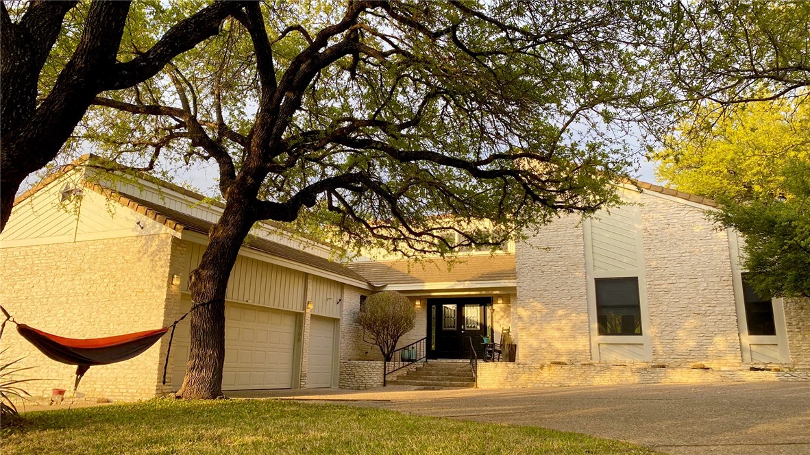 a front view of a house with yard and swimming pool