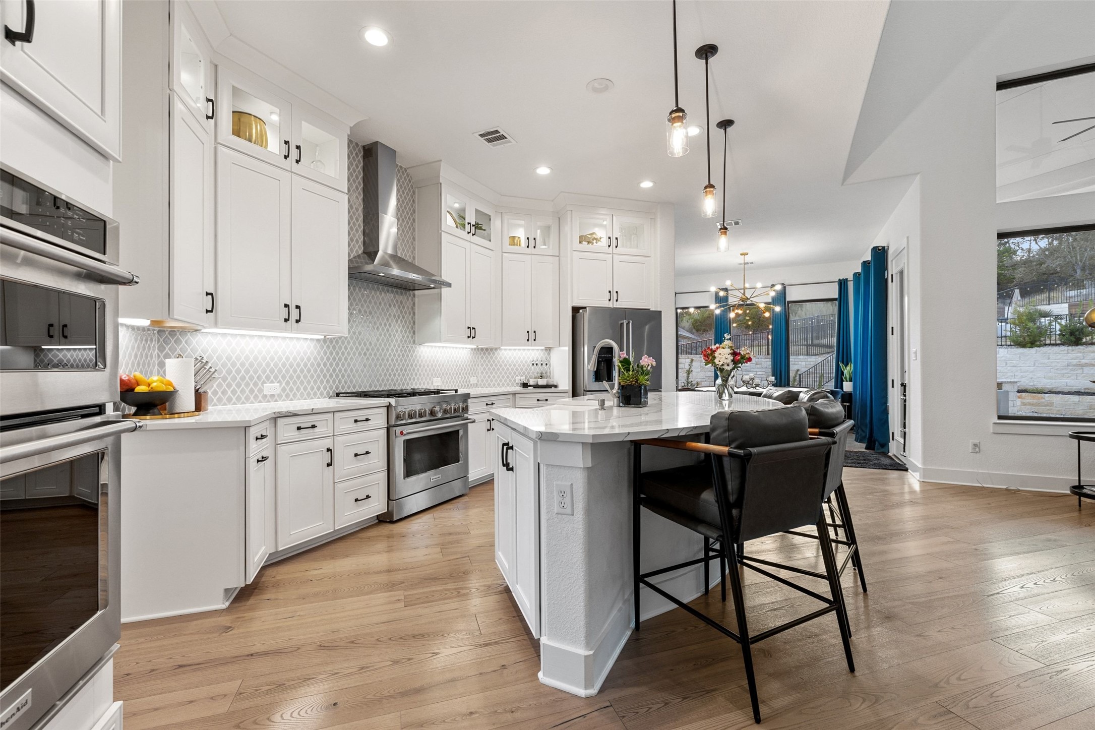 302 Lodestone Lane Austin, TX 78738 - Photo 7 of 40 a kitchen with kitchen island granite countertop wooden floors and white cabinets