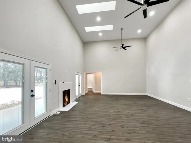 a view of a room with a wooden floor and a ceiling fan