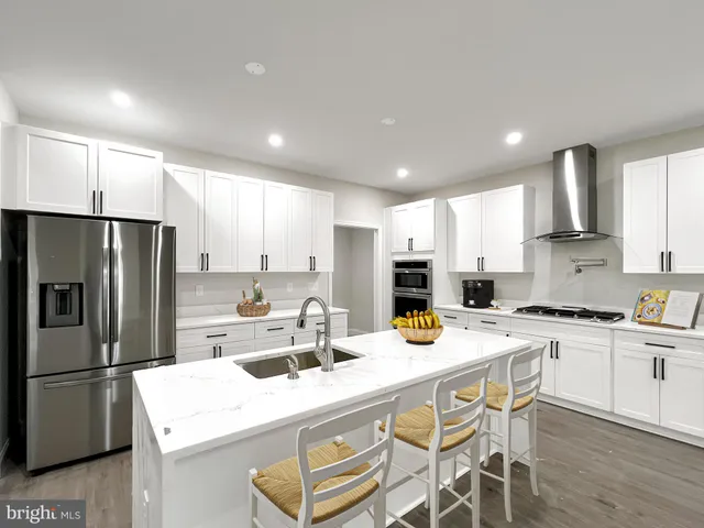 a kitchen with stainless steel appliances granite countertop a sink a stove a refrigerator and cabinets