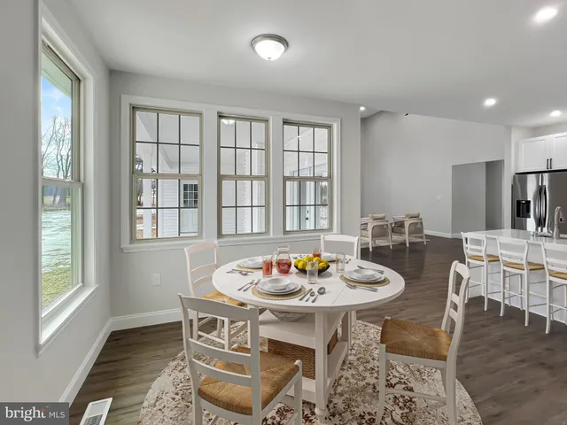 a kitchen with a sink a refrigerator and white cabinets