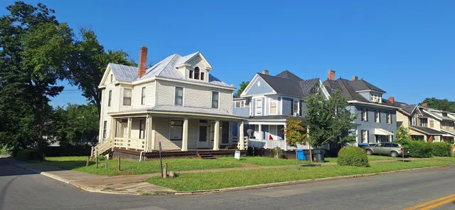 a view of a white house with a yard and plants